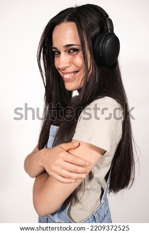 A young casual dressed female musician looking at camera listening to some music