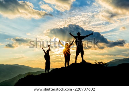 hikers celebrating success on top of a hill in the sunset