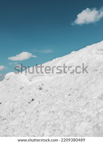 Winter season background, snow on the hill and blue sky with white clouds.