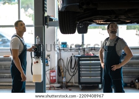 Mechanics preparing the client vehicle for visual inspection Royalty-Free Stock Photo #2209408967