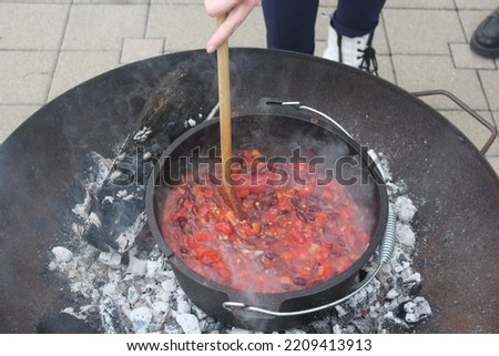A stew being prepared over an open fire.