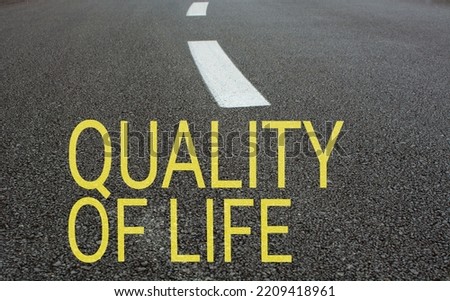 boş asfalt yol ve beyaz yol çizgisi , yolda ''quality of life'' yazılı