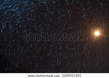 falling snow in the light of a lantern