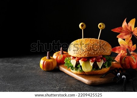 Funny party halloween monster burger on black background, halloween festive, close up