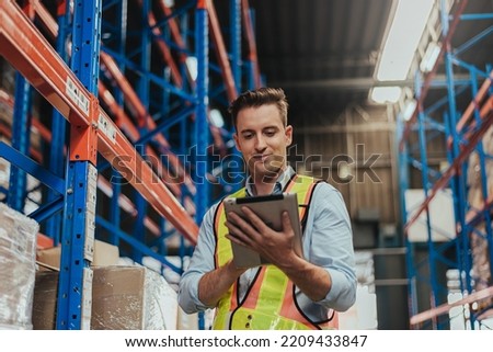 Warehouse Workers checking stock with digital Tablet in Logistic center. Caucasian manager wearing safety vests to working about shipment in storehouse, Working in Storage Distribution Center. Royalty-Free Stock Photo #2209433847