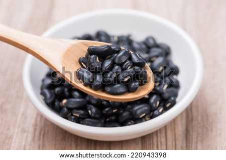 Black Beans in wooden spoon with ceramic bowl Royalty-Free Stock Photo #220943398