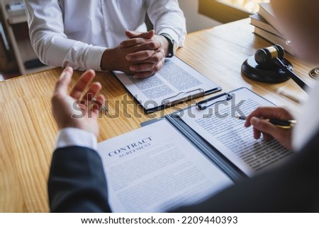 The lawyer working with a client discussing contract paper, a Business lawyer working about legal legislation in the courtroom to help their customer