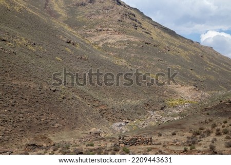 Mountain side with traditional African Lesotho huts rural out of focus with grain