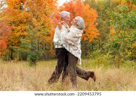 Elderly couple dance in the park in autumn. Full length 