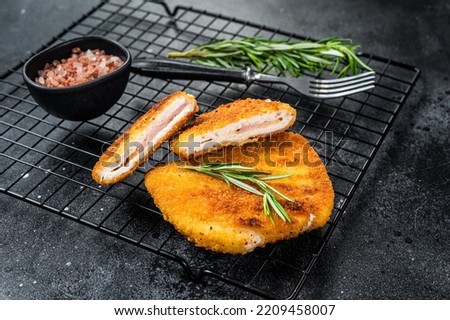 Schnitzel Cordon bleu fillet cutlet with ham and cheese. Black background. Top view. Royalty-Free Stock Photo #2209458007