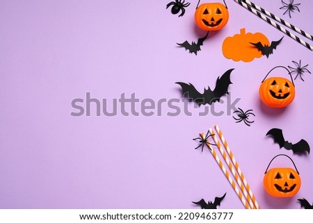 Flat lay composition with paper bats, spiders, plastic pumpkin baskets and cocktail straws on light violet background, space for text. Halloween decor