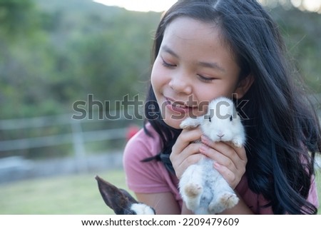 teenage girl with the rabbit. happy little girl holding cute fluffy bunny. friendship with easter bunny. spring photo with beautiful young girl with her bunny. girl is holding a cute little rabbit.