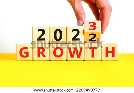 Planning 2023 growth new year symbol. Businessman turns a wooden cube and changes words Growth 2022 to Growth 2023. Beautiful white background, copy space. Business 2023 growth new year concept.
