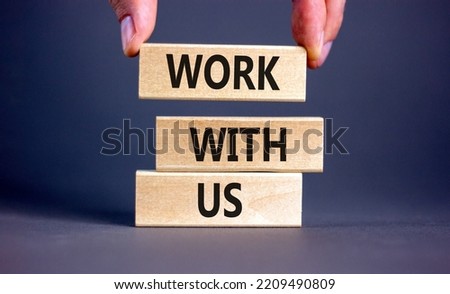 Work with us symbol. Concept words Work with us on wooden blocks on a beautiful grey table grey background. Businessman hand. Business, motivational and work with us concept. Copy space.