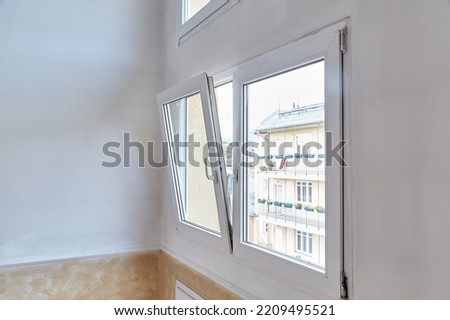 Window tilt open in a city apartment, letting in fresh air Royalty-Free Stock Photo #2209495521