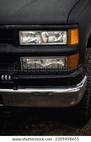 Closeup photo of the front of a black car.  Off-road truck