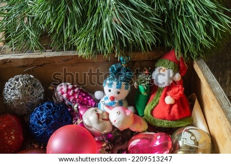 A bunch of old toys for the Christmas tree. Bright objects under green branches close-up