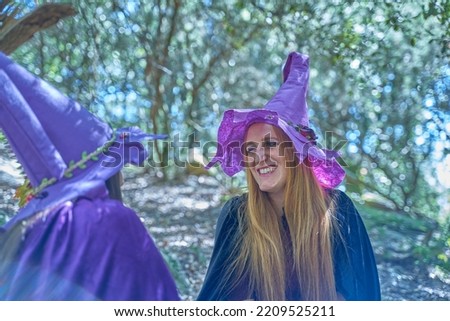 Two young witches playing in the forest