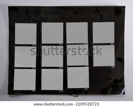 macro photo of black and white hand copy contact sheet with 11 empty film frames. 6x6 medium format film photo placeholder. real dark photo paper.