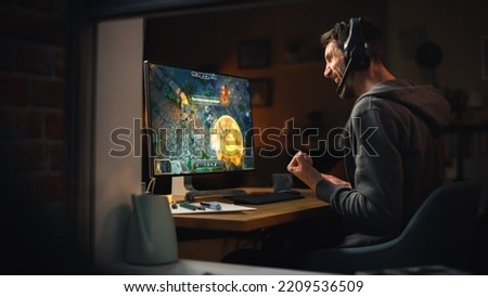 Excited Middle Aged Male Gamer Playing Online Video Game on Personal Computer. Guy Enjoying Fantasy RPG Game with Role Playing Character Casting Spells, Destroy Enemies. Shot from Outdoors. Royalty-Free Stock Photo #2209536509