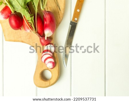 A bunch of red radishes on a wooden background