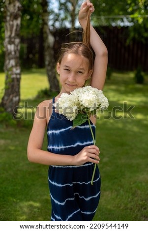 A little girl walks down the street in the village picking a bouquet of flowers for her mom