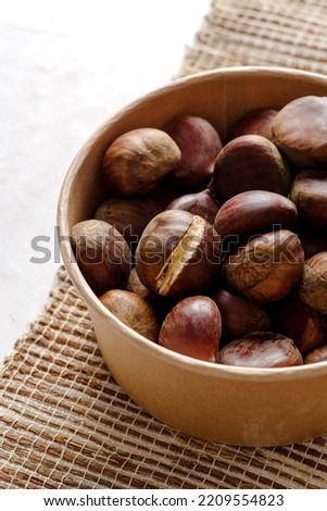 Front view of autumn chestnuts on jute fabric background 