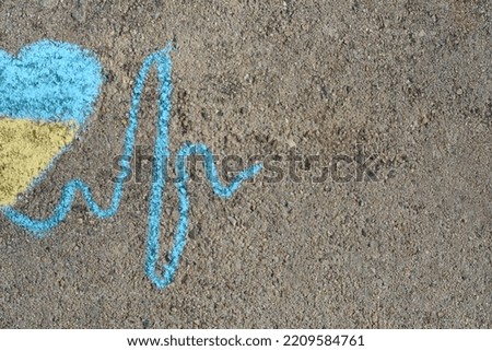Cardiogram line with heart drawn by blue and yellow chalk on asphalt, top view. Space for text