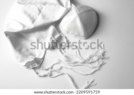 Black and white banner design with prayer shawl tallit and kippah. Jewish national tallith katan - in the form of a cape with brushes. Still Life of Jewish symbols for Sukkot, shabbat, rosh hashanah Royalty-Free Stock Photo #2209591759