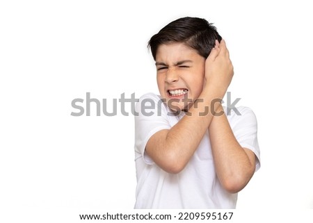 Sad little kid with earache on a white background. Ear ache concept. Royalty-Free Stock Photo #2209595167