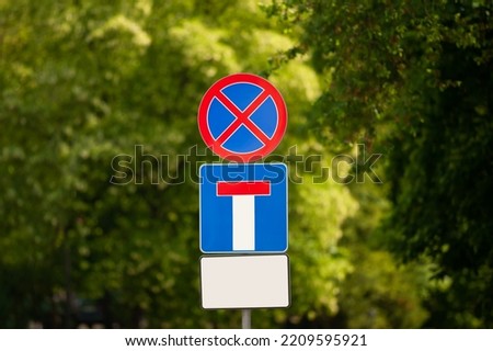 Post with different traffic signs near trees outdoors