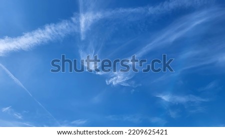 Blue sky with light white clouds on a sunny summer day.