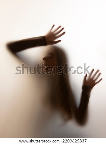shadow of a girl behind transparent paper