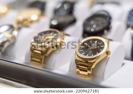 High-end gold-colored watches, exposed behind the window of a watch shop Royalty-Free Stock Photo #2209627185