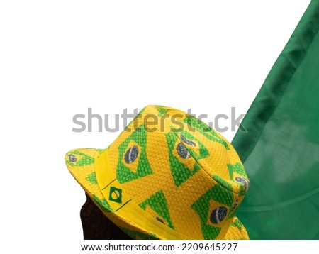 Brazil flags painted on yellow straw hat on person's head cut out and isolated from the background. Brazilian green and yellow patriotism.