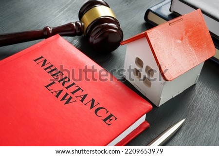 Inheritance law book, model of house and gavel.