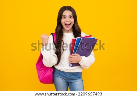 School teenager child girl 12, 13, 14 years old with book and copybook. Teenager schoolgirl on isolated background. Learning and knowledge education concept. Excited teenager girl.