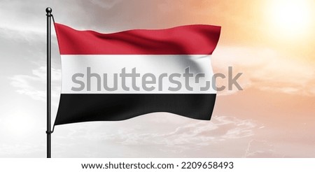 Yemen national flag cloth fabric waving on beautiful grey sky.