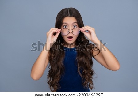 Cute school girl wearing glasses on yellow studio background, smart clever schooler girl in eyeglasses. Nerd student, genius schoolgirl, School, education concept.