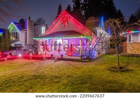 House with garage door, big tree and nice Christmas decoration at night in Vancouver, Canada, North America. Night time on Dec 2021.