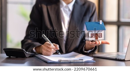 Close up house model with business man signs a purchase contract or mortgage for a home, buy and sell home insurance concerning mortgage loan Real estate concept.