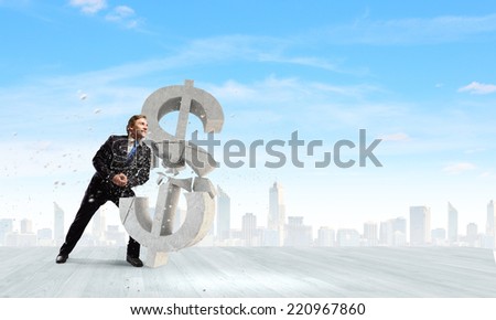 Young businessman breaking stone dollar sign. Currency concept