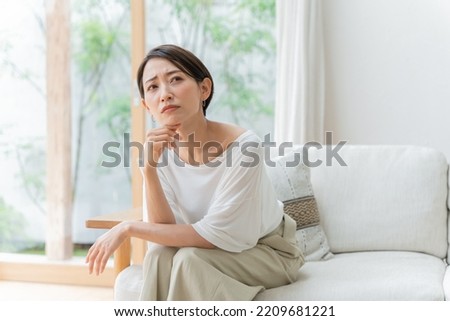 Middle-aged Asian woman in distress Royalty-Free Stock Photo #2209681221