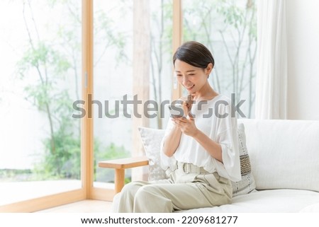 Asian woman looking at smartphone in the room