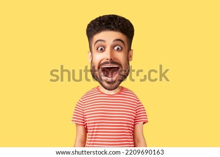 Caricature comic portrait of surprised funny young adult man looking at camera with open mouth and amazed big eyes, expressing astonishment. Indoor studio shot isolated on yellow background Royalty-Free Stock Photo #2209690163
