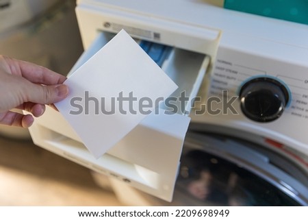 Woman putting a laudry sheet in the washing machine