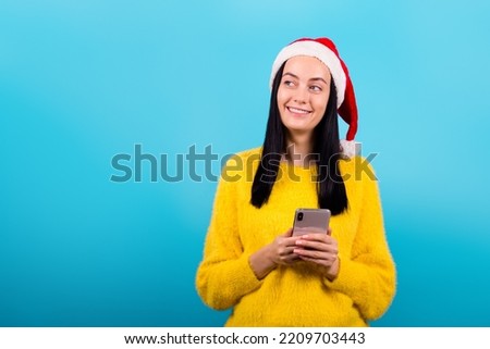 Photo of a positive beautiful girl looking away, chatting, talking on the telephone on a blue color background
