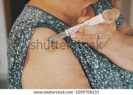 Close up of woman arm with insulin pen. Mature lady injecting diabetes treatment with syringe. Concept of diabetic people taking care. Health and age lifestyle. Senior female diabetes take insulin Royalty-Free Stock Photo #2209708231
