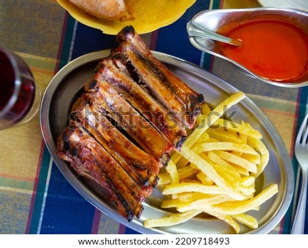 Image of pork barbeque ribs with french fries served with ketchup