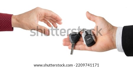 hand of businessman passing car keys to hand, isolated on white